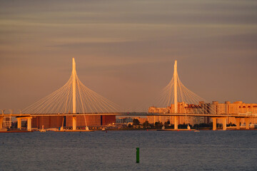 Fototapeta na wymiar Sailing boats in the background of the new cable stayed bridge in sunset