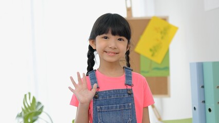 Close up portrait of little girl nice look attractive charming cute lovely cheerful girl after finish school. Multi-ethnic preschool teacher and students classroom. Child education on free time.