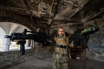 Fototapeta premium Caucasian woman in army uniform holding two machine guns. 