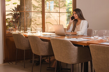 beautiful young business girl talking on the phone in the restaurant.