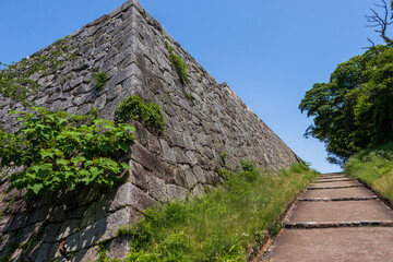 Fototapeta na wymiar 高い石垣に沿って続く城跡の小道