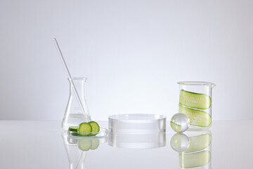 Front view of transparent podium with laboratory equipment and cucumber in white background science content