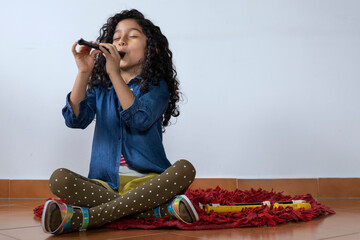 Latin American girl plays the piccolo recorder - obrazy, fototapety, plakaty