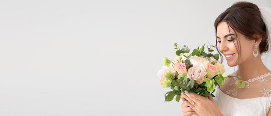 Beautiful young bride with bouquet of flowers on light background. Banner for design