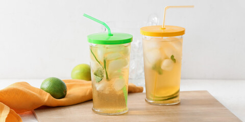 Glasses of tasty cold ice tea on light background