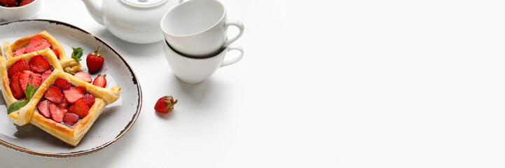 Plate with sweet strawberry puff pastries on light background with space for text