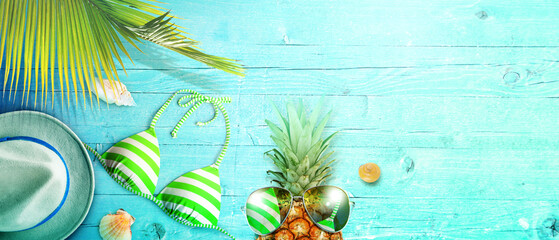Fototapeta na wymiar Nautical concept with palm leaf, beach hat, seashells and pineapple.