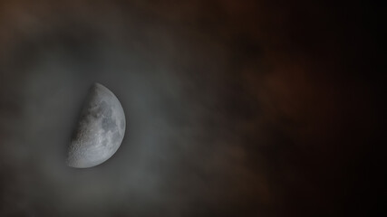 Half moon seen in clouds at night
