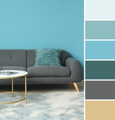 Stylish coffee table and sofa near blue wall. Different color patterns