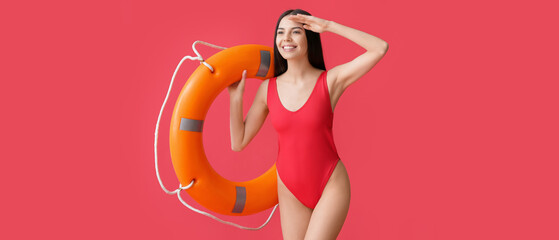 Female beach rescuer holding lifebuoy on red background