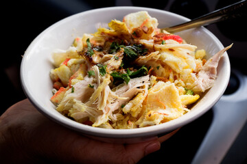 Bubur ayam or Indonesian rice porridge served with shredded chicken. 