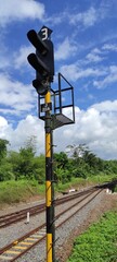 A train traffic light with orange and black poles in the Banjar area, Indonesia