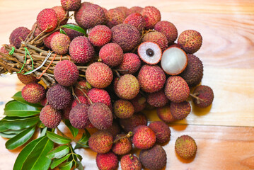 Lychee fruit on wooden background with green leaf , fresh ripe lychee peeled from lychee tree at tropical fruit Thailand in summer