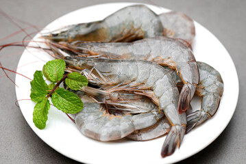 raw shrimp on white plate with mint leaf and shrimps background for cooking, close up fresh shrimps or prawns, seafood shelfish