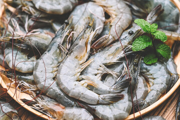 raw shrimp on white plate with mint leaf and shrimps background for cooking, close up fresh shrimps or prawns, seafood shelfish