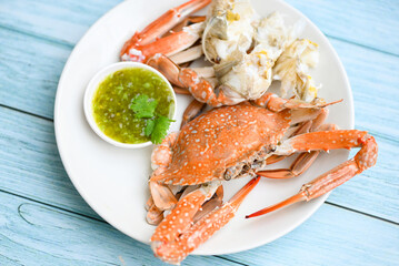 seafood plate fresh crab cooking on white plate background , blue swimming crab meat claw served on a food table - cooking steamed crab with seafood sauce top view