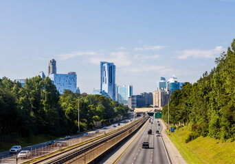 North Atlanta neighborhood of Buckhead displaying several buildings, city streets, hotels and high rises under a blue sky. - obrazy, fototapety, plakaty