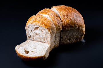 Fresh whole wheat bread with a coffee mug on black background. Healthy eating breakfast.
