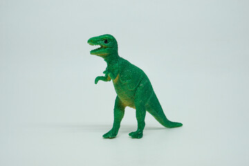 Side view of plastic green Tyrannosaurus rex dinosaur plastic toy for kids, isolated on a studio lighting background