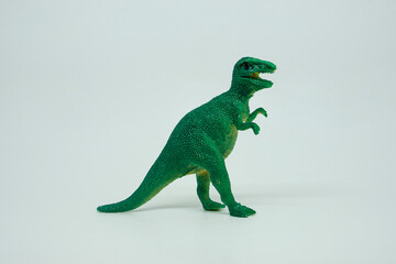 Side view of plastic green Tyrannosaurus rex dinosaur plastic toy for kids, isolated on a studio...