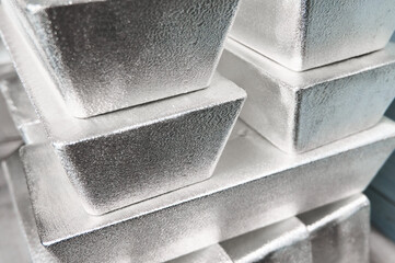 Pile of industrial silver bars at bright light in storage