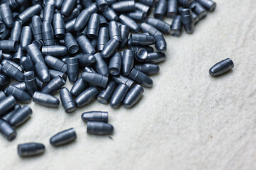 Small caliber hunter bullets lie on light fabric sheet