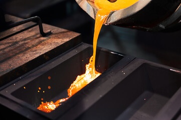 Molten silver is poured from a small ladle.