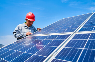 Asian engineers are carefully inspecting the details of solar photovoltaic panels