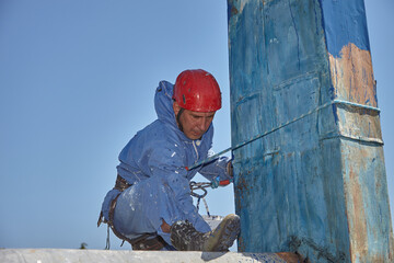 A specialist is repairing the roof. Rope access