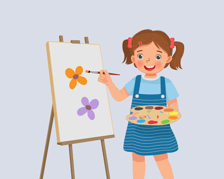 cute little girl artist holding color palette and paintbrush painting on the canvas 