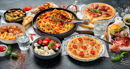 Italian food assortment on dark background.