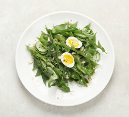 Fresh dandelion salad on light background.