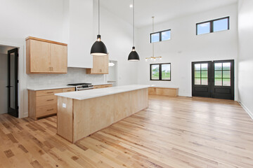 large empty kitchen with black windows and natural finished hardwood flooring