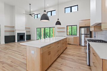 large empty kitchen with black windows and natural finished hardwood flooring