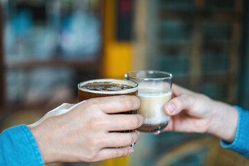 Close up of young couple hands clinking or toasting glasses of coffee talking sharing showing love...