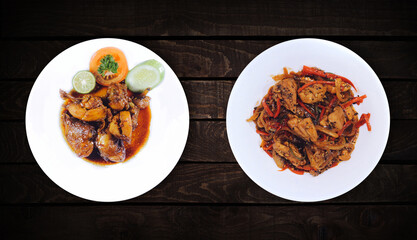 Side dishes, bean vegetable dish and chicken spicy are on white plate on dark wooden background, top view.