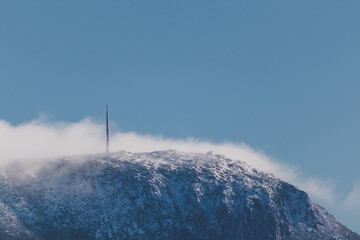 Obraz premium Snow on the mountain tops with clouds rolling over the pinnacles shot in Tasmania