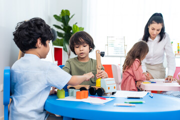 Caucasian beautiful woman teacher teaching a lesson to kid at school. 