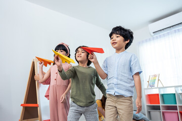 Group of Mixed race young little kid playing airplane in schoolroom. 