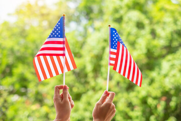 hand holding United States of America flag on green background. USA holiday of Veterans, Memorial, Independence ( Fourth of July) and Labor Day concept