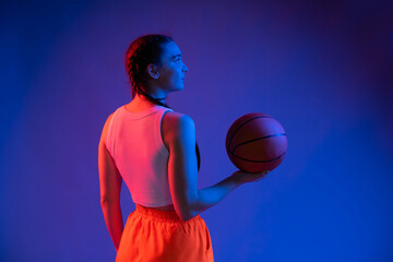 Fototapeta premium sports girl in the studio in shorts, a T-shirt with a basketball. blue background. sport concept. sports, healthy lifestyle