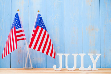 July text and United States of America flag on wooden table background. USA holiday of Independence and celebration concepts