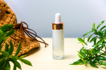 Beautiful white cosmetic bottle and decorated with green leaves.