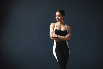 Fototapeta na wymiar Beautiful athletic woman in black and white sportswear posing in the studio.