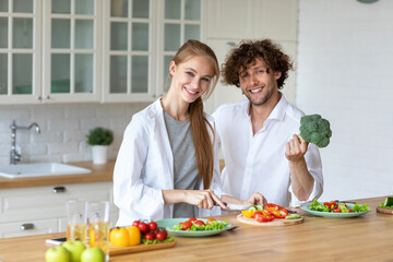 Obraz na płótnie Canvas Young beautiful healthy couple preparing a vegetarian breakfast. Spending time together at home, healthy food.