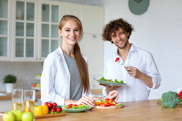 Young beautiful healthy couple preparing a vegetarian breakfast. Spending time together at home, healthy food.