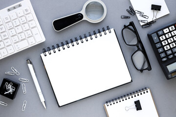 top view of open notebook with pen on gray background, spiral spring notebook, flat notepad in office near keyboard glasses calculator