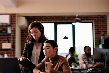 Young adult with physical impairment brainstorming ideas with manager, paralyzed wheelchair user doing teamwork. Entrepreneur with health condition working in disability friendly office.