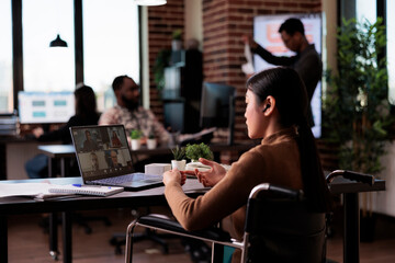 Employee with physical impairment attending videocall meeting in disability friendly office, chatting with people on online videoconference. Wheelchair user talking on remote teleconference.