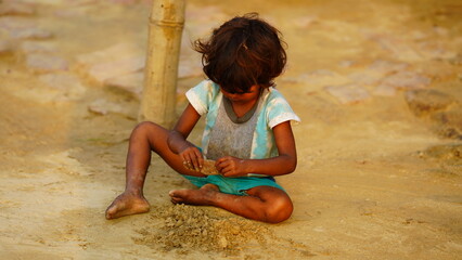 poor alone baby girl playing in soil